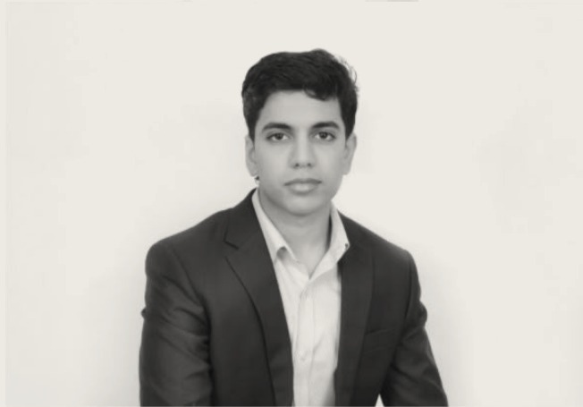 Portrait of the founder and chief executive in a dark suit against a pale studio backdrop